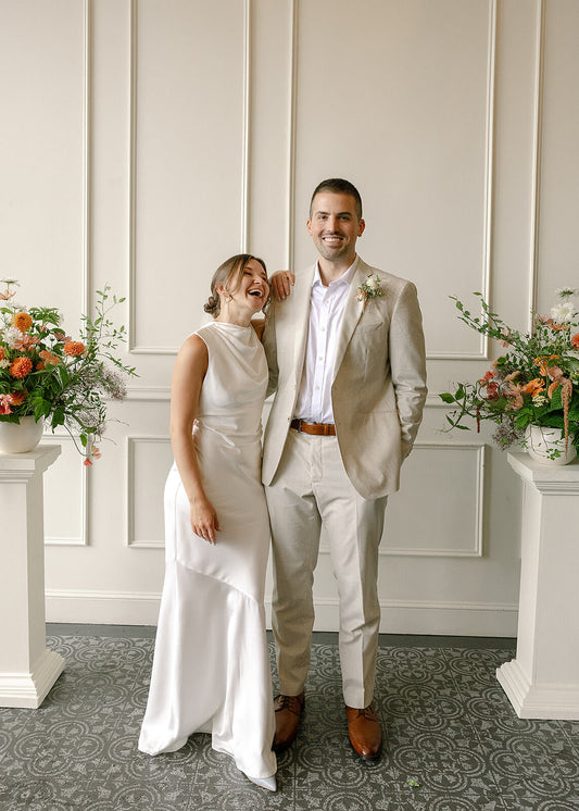 Bride and groom smiling in front of floral ceremony setup at Tendue