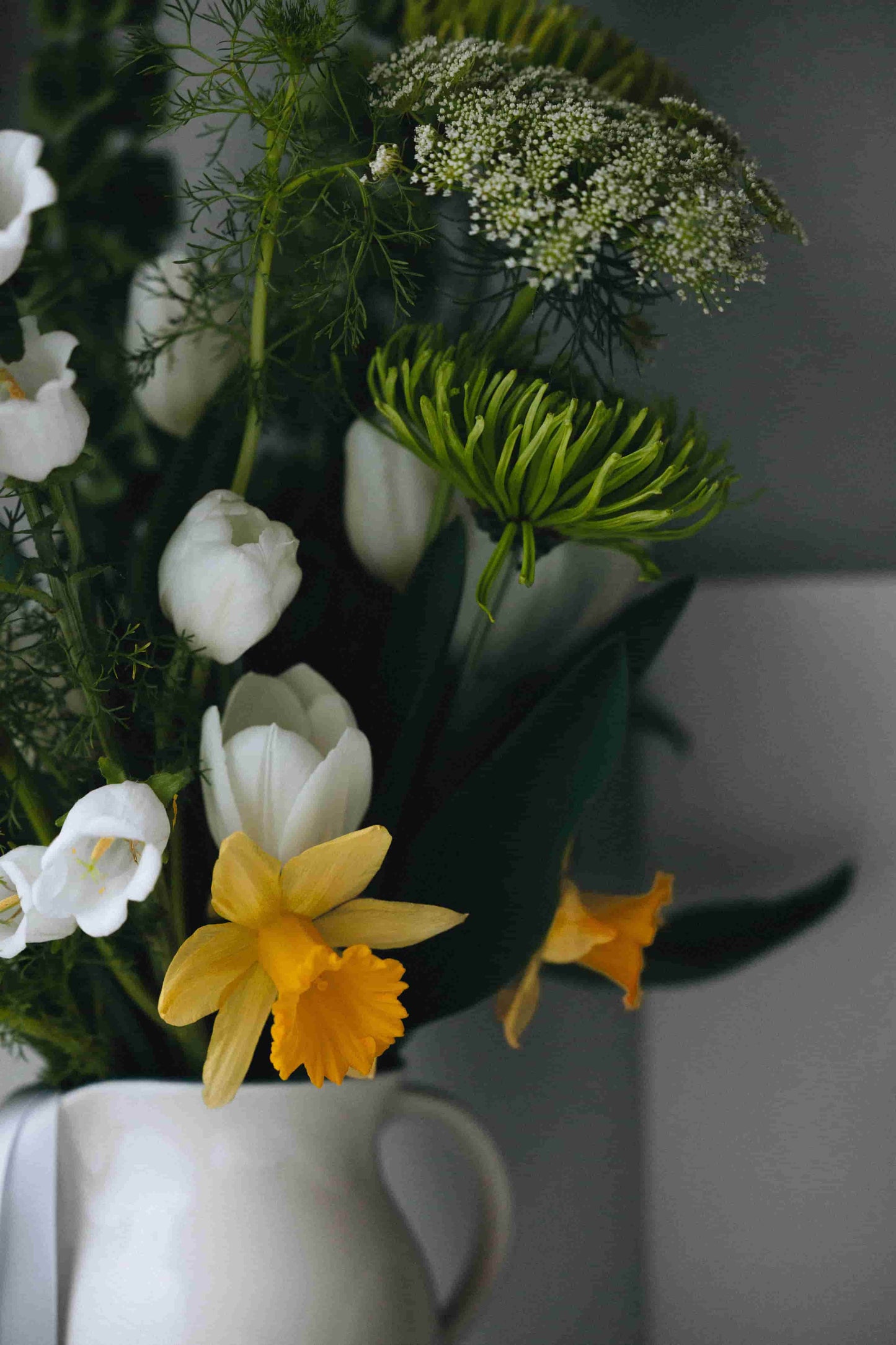 Green mums, white tulips and daffodils in ceramic pitcher – part of Kvetka Flower’s Deluxe Subscription