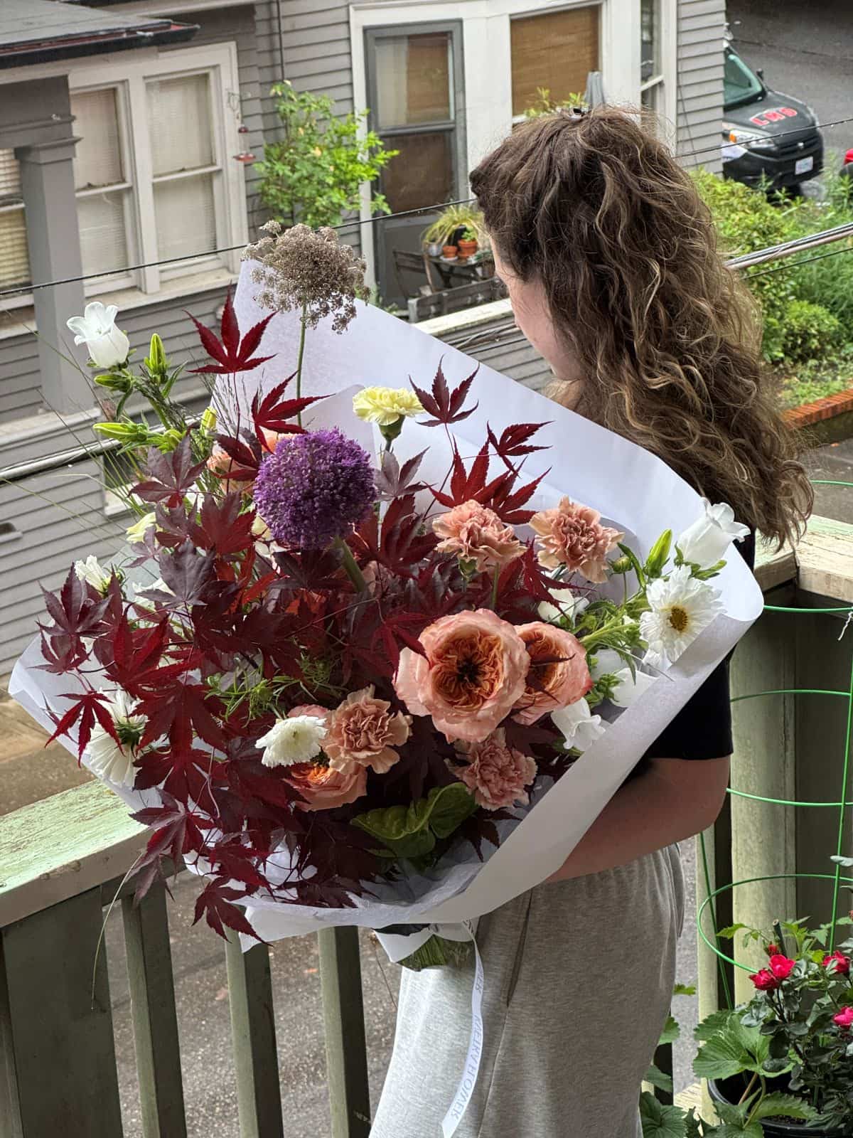 Extra large seasonal bouquet with deep red Japanese maple foliage, peach carnations, garden roses and purple allium in white wrap, by Kvetka Flower