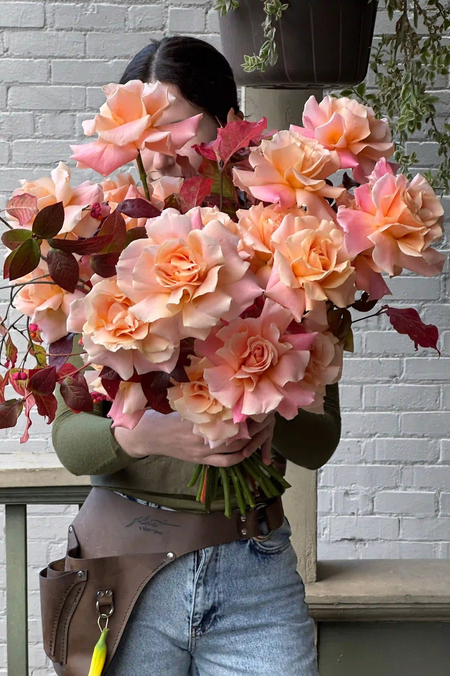 Hand-crafted seasonal rose bouquet in peach tones with burgundy accents by Kvetka Flower for same-day delivery