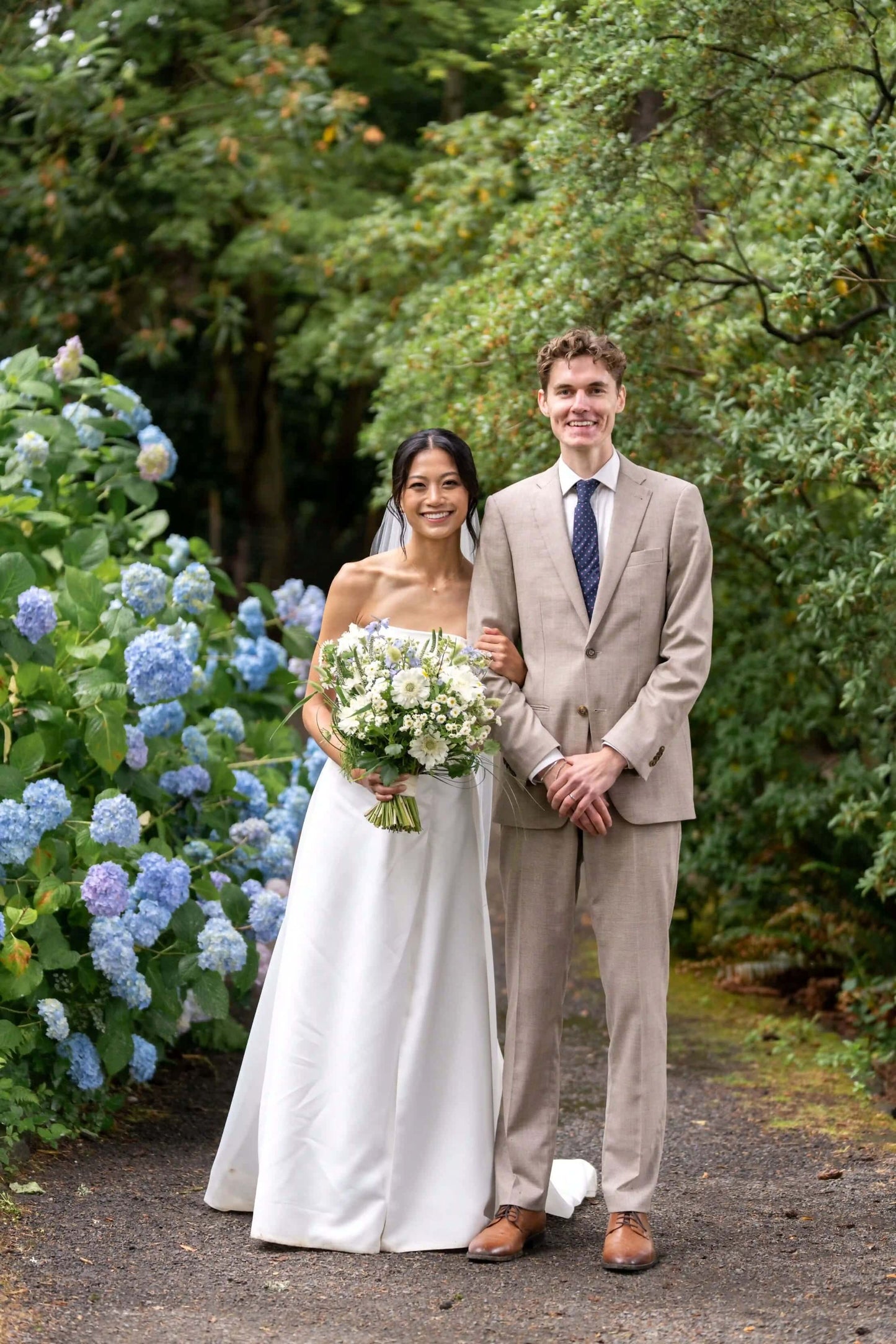 Bride and groom portrait with a large Kvetka Flower bouquet featuring white and pastel flowers