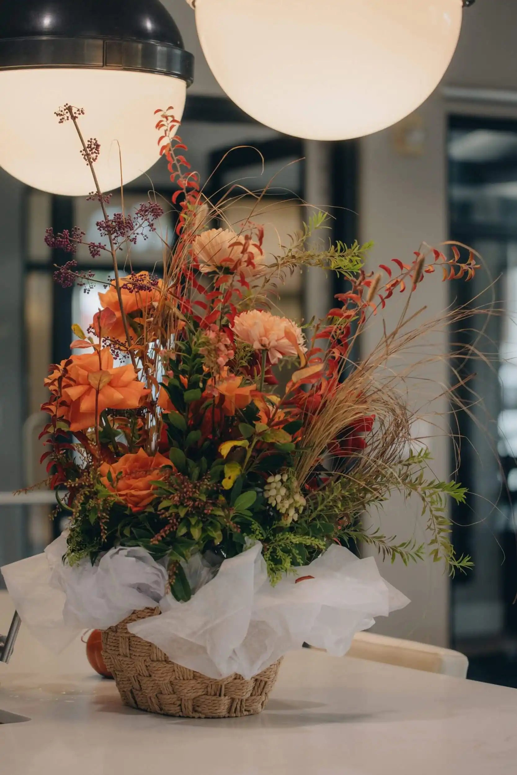 Garden-style flower basket with red roses, orange dahlias, and autumn foliage by Kvetka Flower