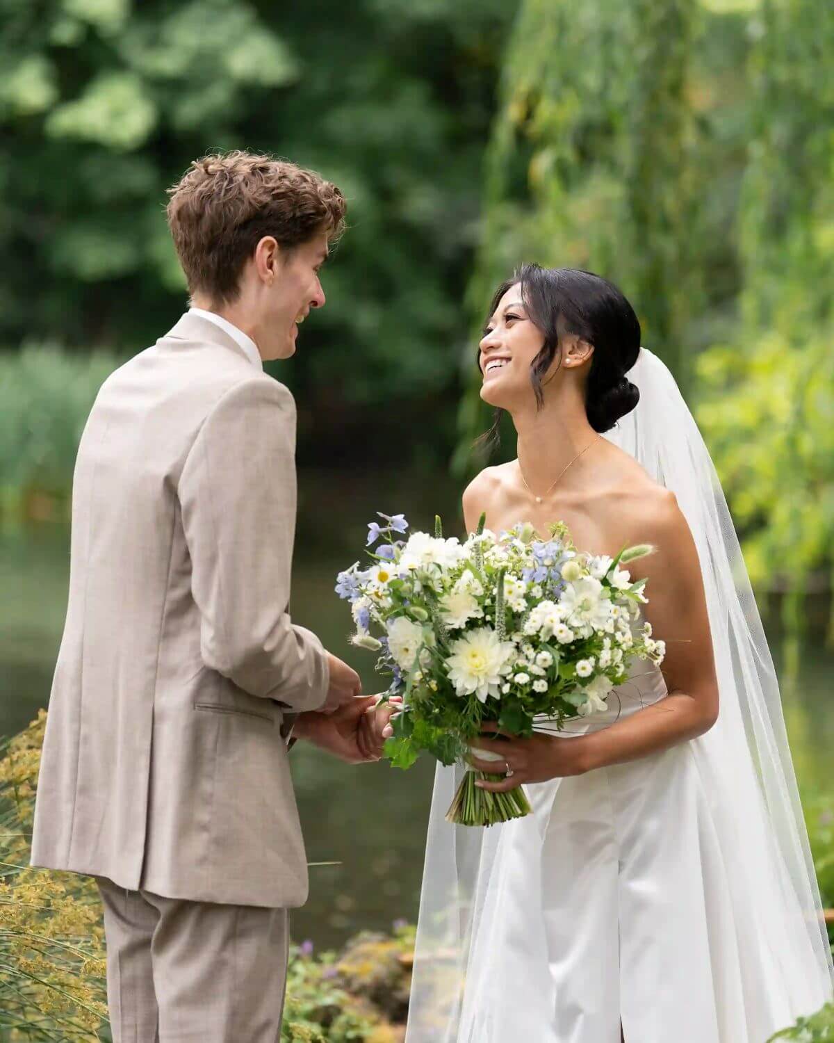 Bride and groom exchanging vows with Kvetka Flower bouquet in hand, lush garden backdrop