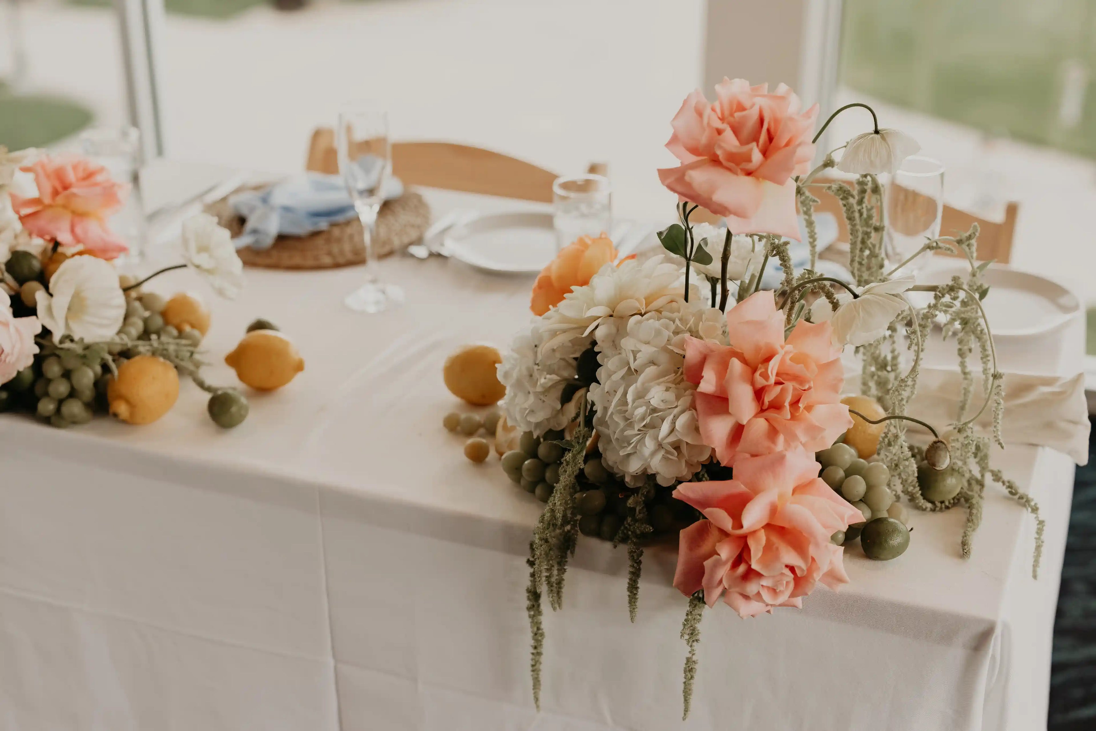 Floral decor for a wedding sweetheart table with garden roses, hydrangeas, citrus fruits and vines — designed by Kvetka Flower in Vancouver, WA.